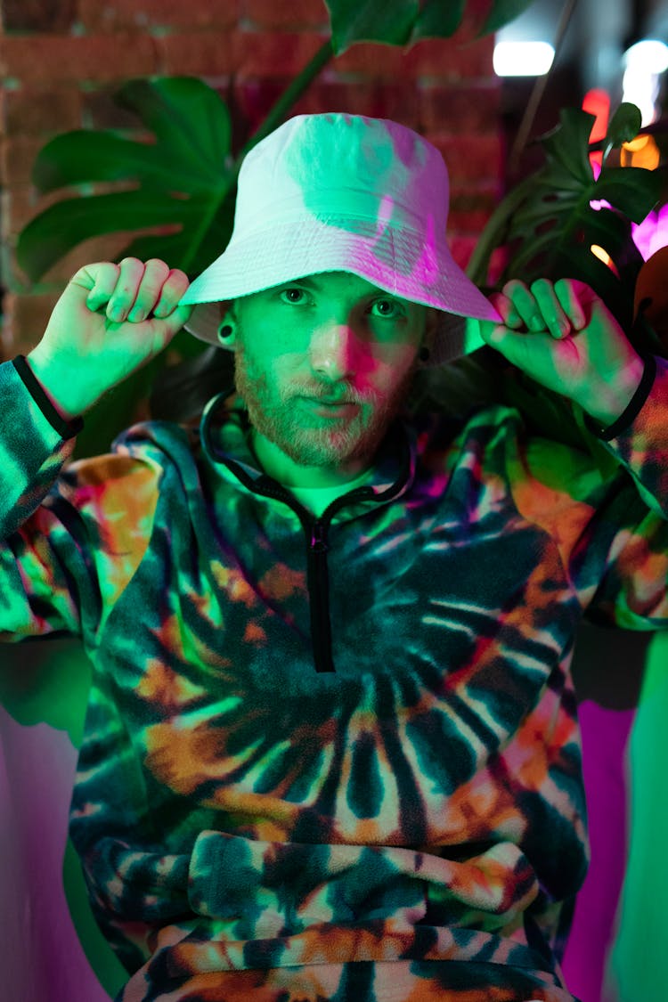 A Man Wearing A Bucket Hat And A Tie Dye Sweater