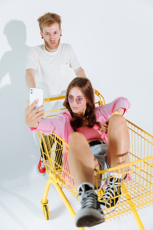 Man in White Crew Neck T-shirt Sitting Beside Woman in Red Sleeveless Dress