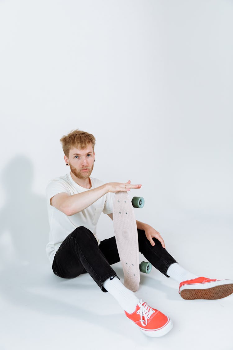 A Man Holding A Skateboard