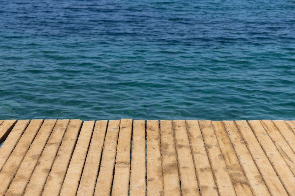 Las tablas de un muelle de madera se extienden sobre aguas azules