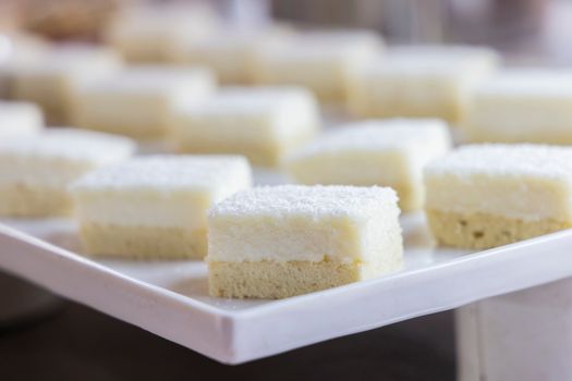 Close-up of delicious coconut cream dessert squares on a platter.