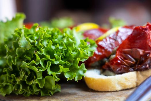 Close-up of vibrant lettuce and grilled vegetables on bread, showcasing healthy eating.
