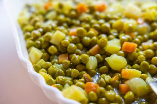 Free Close-up of a delicious mixed vegetable side dish featuring peas, carrots, and potatoes. Stock Photo