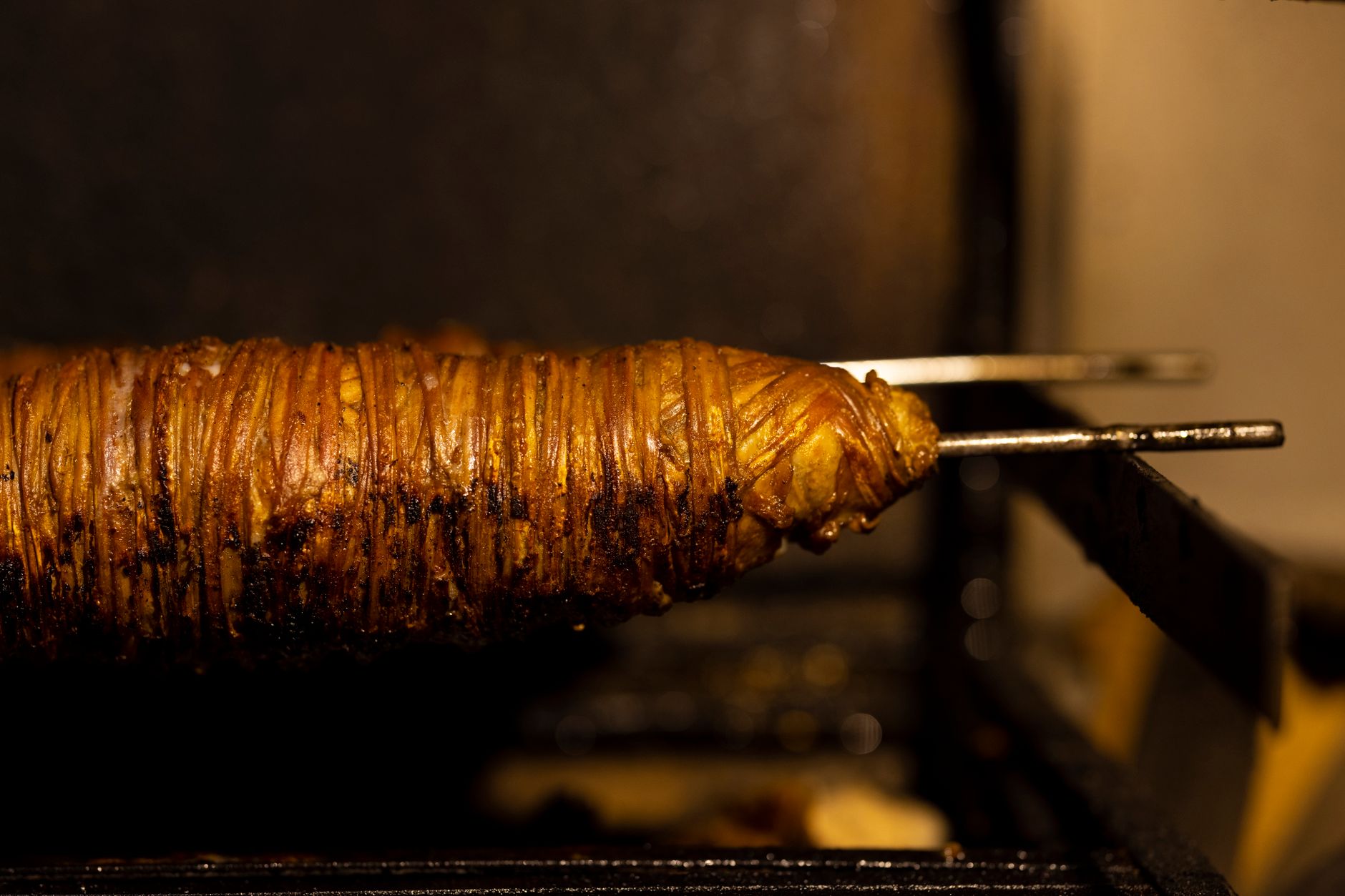 Succulent kokoretsi roasting on a skewer, capturing rich flavors and texture.