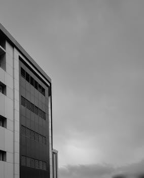 Grayscale image of a modern high-rise building with sleek architectural lines in Mangalore, India.