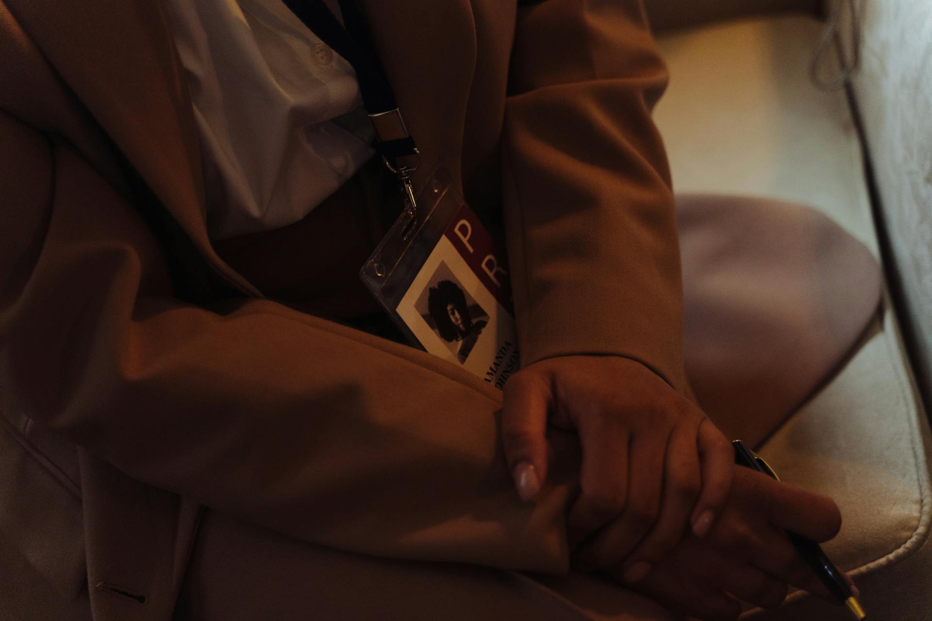 A Person in Brown Coat Weaering Identification Badge