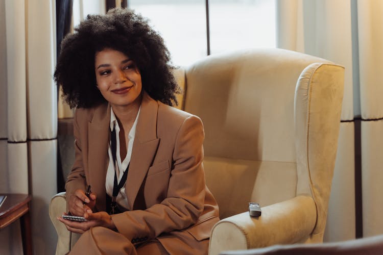 A Woman Taking Notes While Sitting