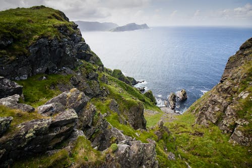 Green and Gray Rock Formation Beside Body of Water