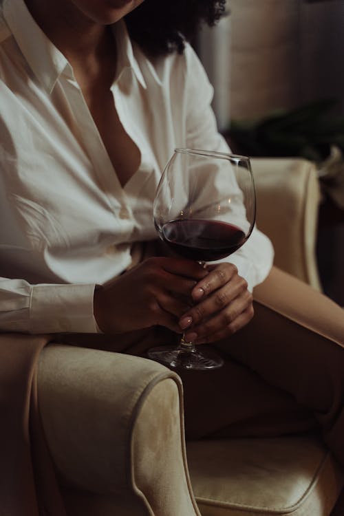 Free Woman in White Long Sleeve Shirt Holding a Glass of Red Wine Stock Photo