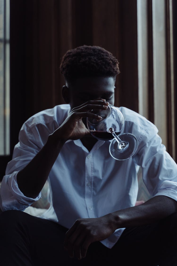 A Man Drinking A Glass Of Wine