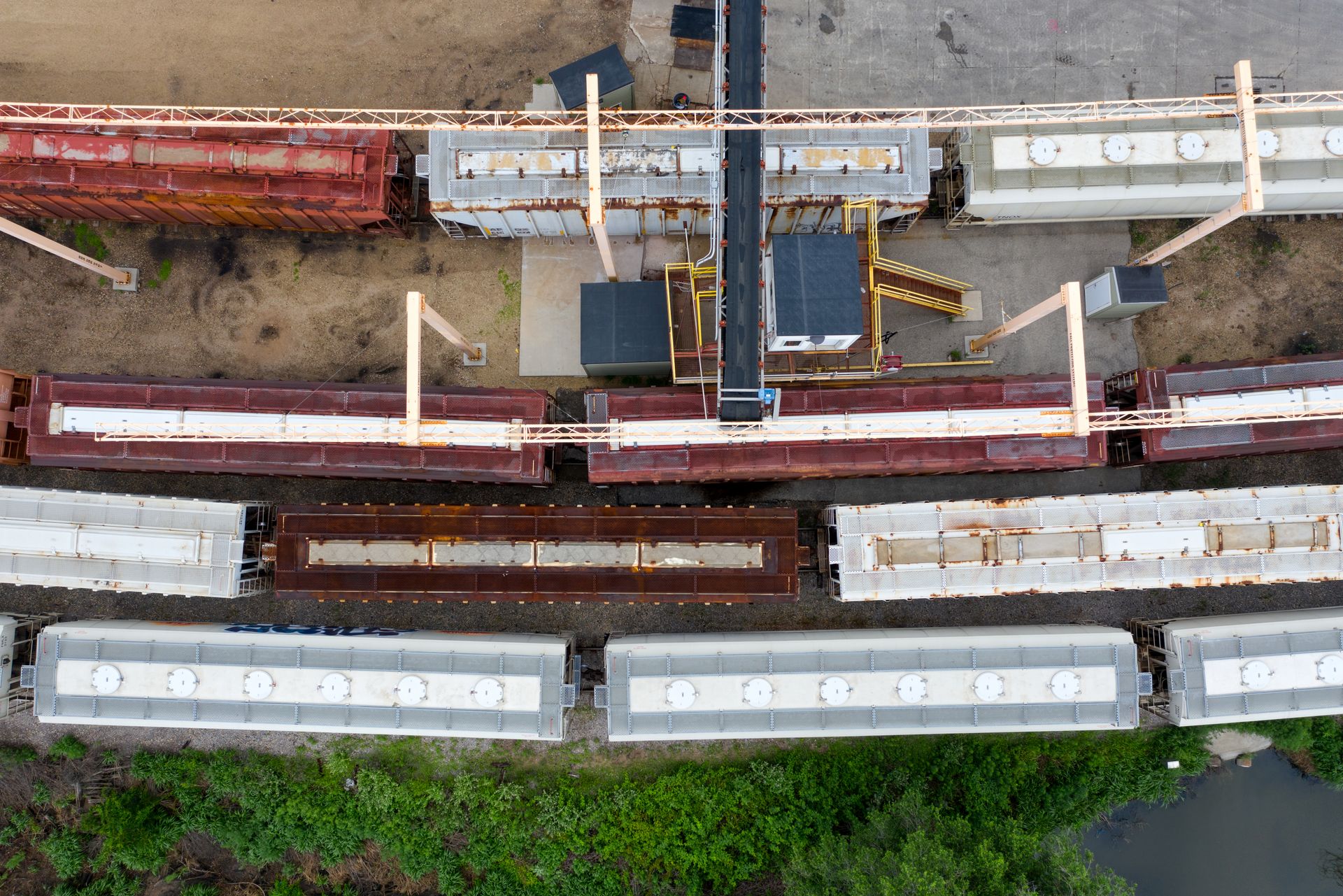 Overhead drone shot of a bustling train yard with cargo trains and machinery in Winona, MN.
