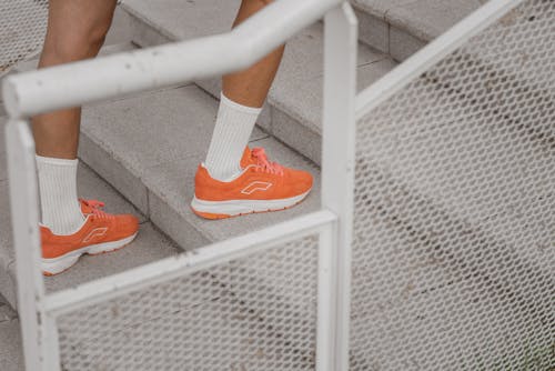 Free Person in Orange Sneakers Going Up the Stairs Stock Photo