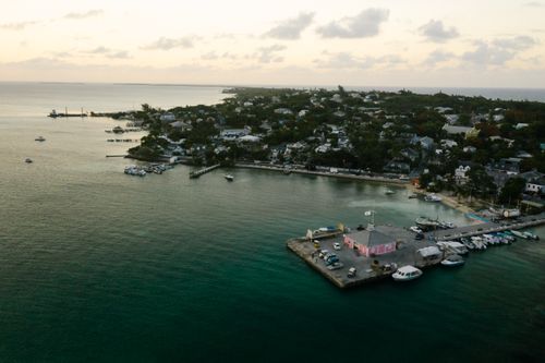 Free Experience the tranquil beauty of Harbor Island's coastline at sunset near a bustling marina. Stock Photo
