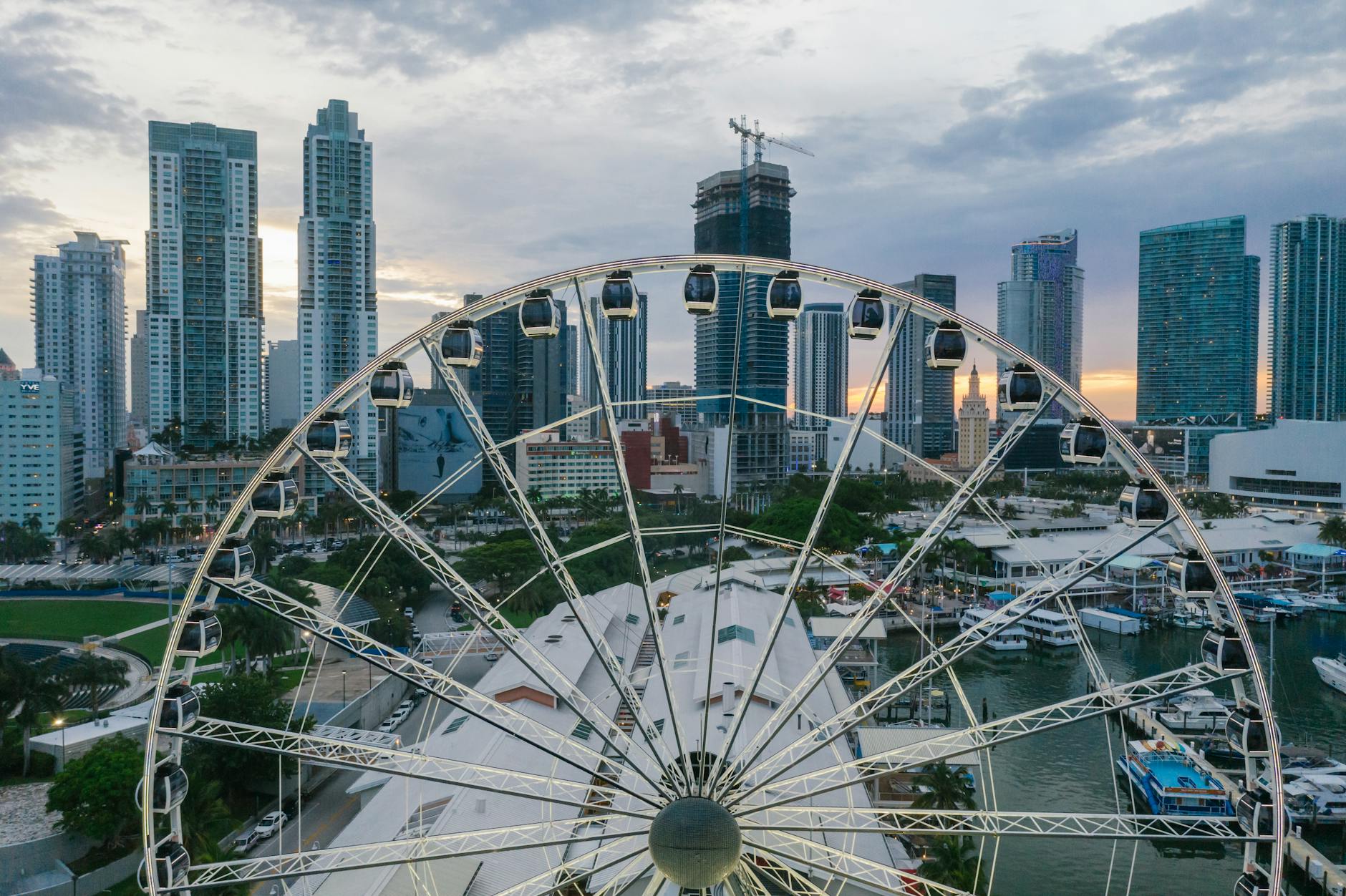 Miami skyline at dusk from a Ferris wheel, featuring high-rise buildings and colorful urban landscape