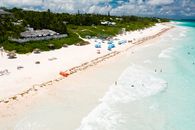 Stunning aerial shot of a tropical beach with clear water and white sand, offering a perfect getaway scene.