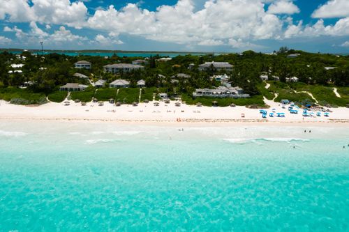 Free Aerial view of a serene tropical beach with turquoise waters and white sand, perfect for relaxation. Stock Photo