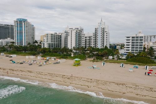 Free Aerial view of beachfront cityscape with tall buildings and sandy shore. Stock Photo