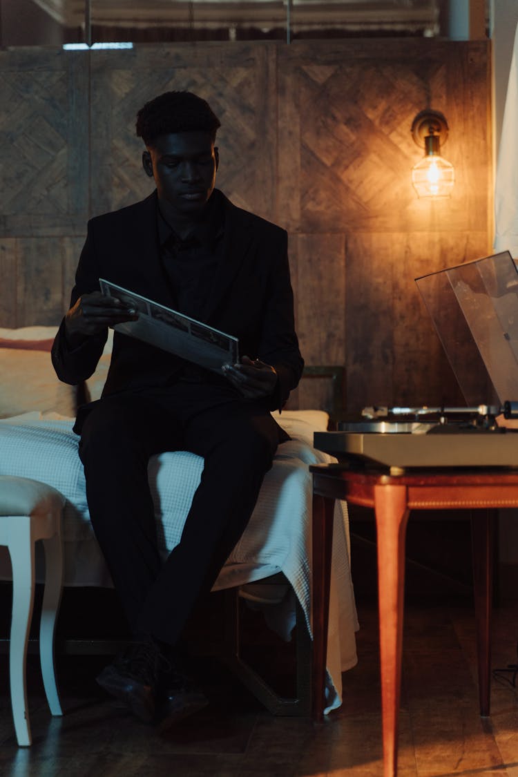 Man In Black Suit Holding A Vinyl Record