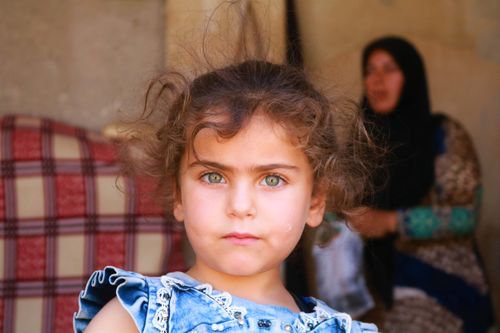 Free Expressive close-up of a young girl with striking eyes in Idlib, Syria. Stock Photo