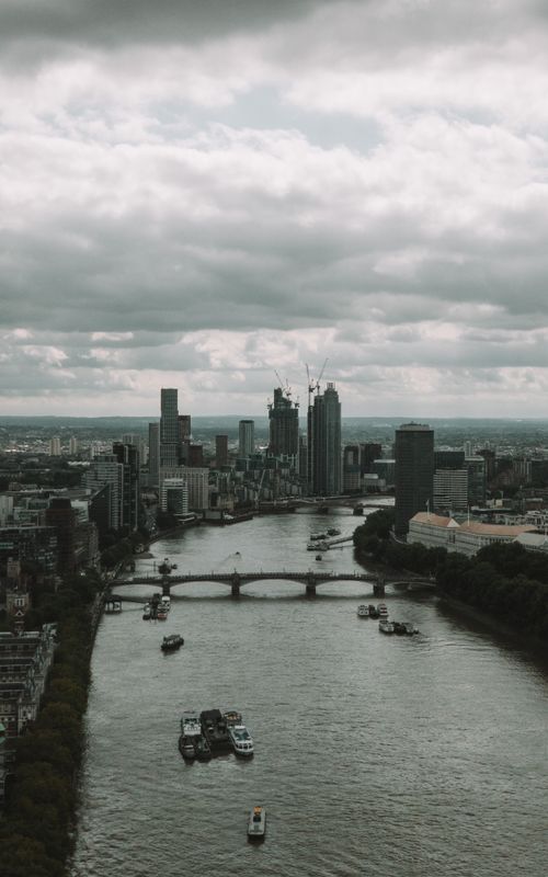 Free Aerial view of the River Thames with iconic London skyline and cityscape under cloudy sky. Stock Photo