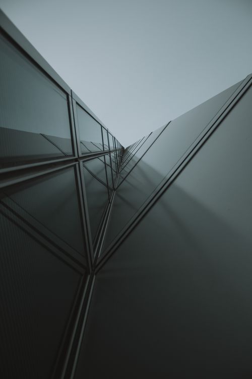 Free Modern skyscraper architecture with glass and steel facade viewed from below. Stock Photo