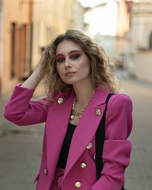 Woman in Pink Blazer Standing on an Alley