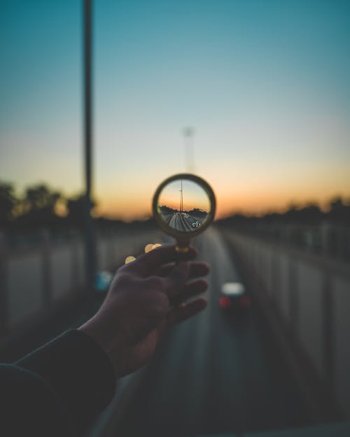 A Hand Holding a Magnifying Glass