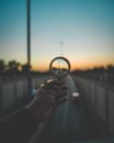 Person Holding Magnifying Glass during Sunset