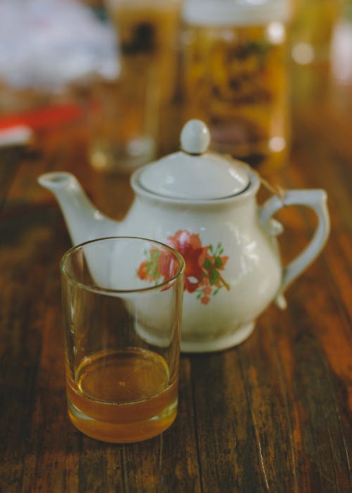 Drinking Glass Beside a Tea Pot