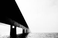 这幅艺术作品捕捉了水面雾气中若隐若现的桥梁，传达出神秘与宁静的氛围