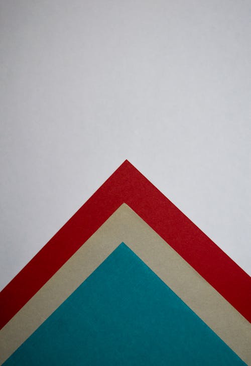 Close-Up Shot of Colored Papers on a White Surface