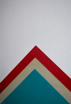 Close-up of a geometric pattern created with vibrant colored papers over white background, ideal for design concepts.