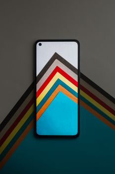 Modern smartphone with vibrant geometric background for tech concepts.