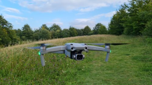 Free Aerial drone hovering over a green field with trees in Sharpenhoe, England. Stock Photo