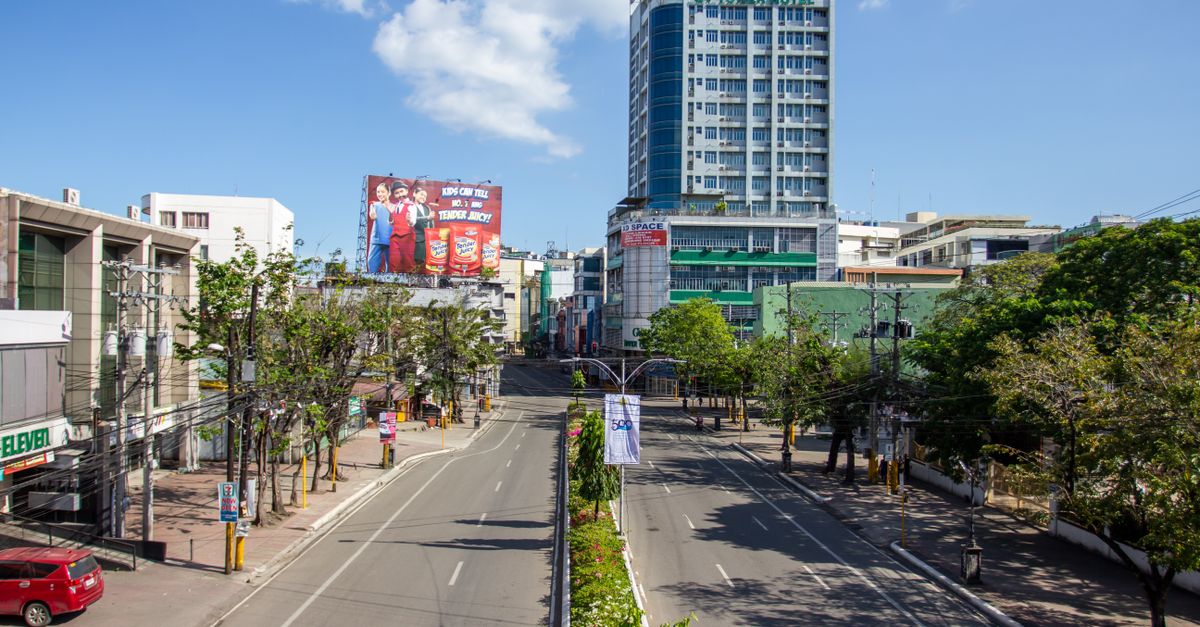 A vibrant street in Cebu City, Philippines, showcasing modern architecture and clear blue skies.
