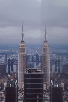 A mesmerizing view of the New York City skyline with the Empire State Building under a gloomy sky.