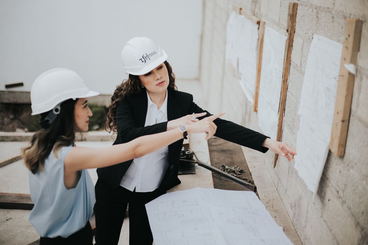 Two architects discussing building plans outdoors