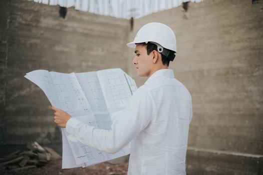 Architect examining blueprints at a construction site in Mexico.