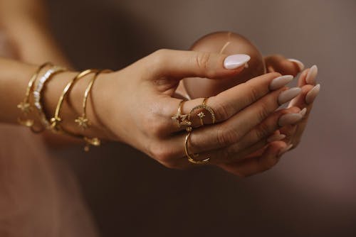 Person Wearing Gold Rings and Gold Bracelets