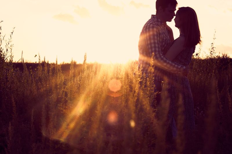 Couple embracing in a golden field at sunset