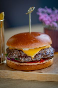 Delicious cheeseburger with fresh ingredients and toothpick skewer, perfect for burger lovers.