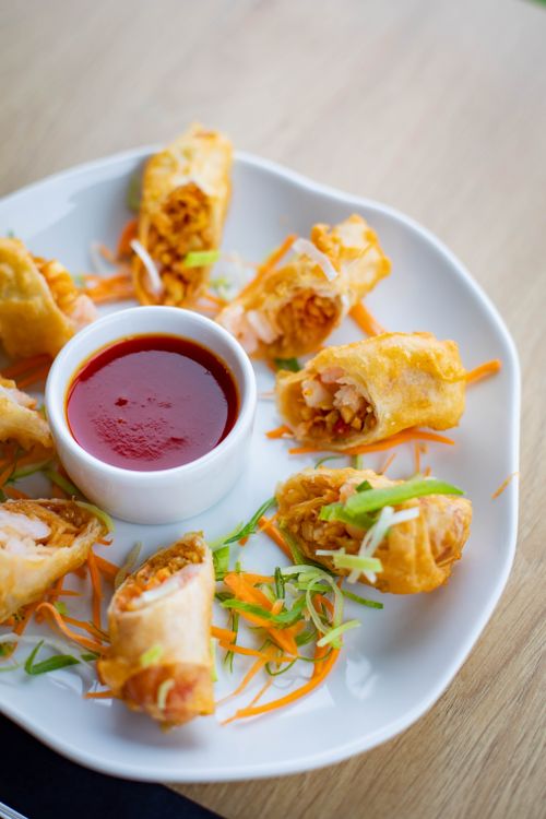 Free Delicious crispy spring rolls served with a tangy dipping sauce, perfect for a tasty appetizer. Stock Photo
