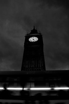Moody black and white photo of Big Ben with cloudy sky and motion blur.