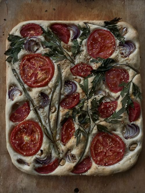 Free Mouthwatering focaccia topped with fresh tomatoes and herbs, homemade style. Stock Photo