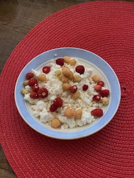Top view of fresh strawberries on creamy cottage cheese in a bowl.