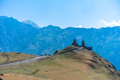 Free Stunning view of Gergeti Trinity Church atop a hill against majestic Georgian mountains. Stock Photo