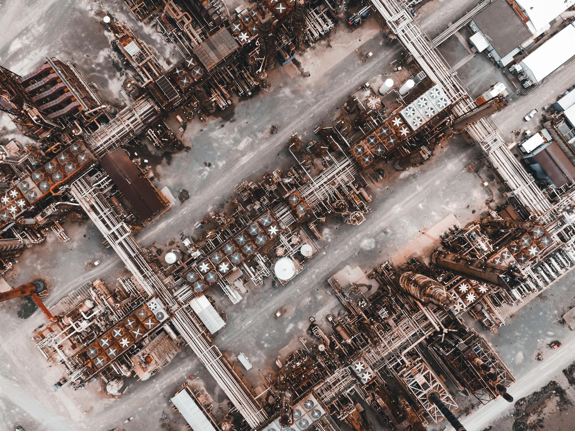 Drone shot capturing the intricate layout of a large industrial factory from above.