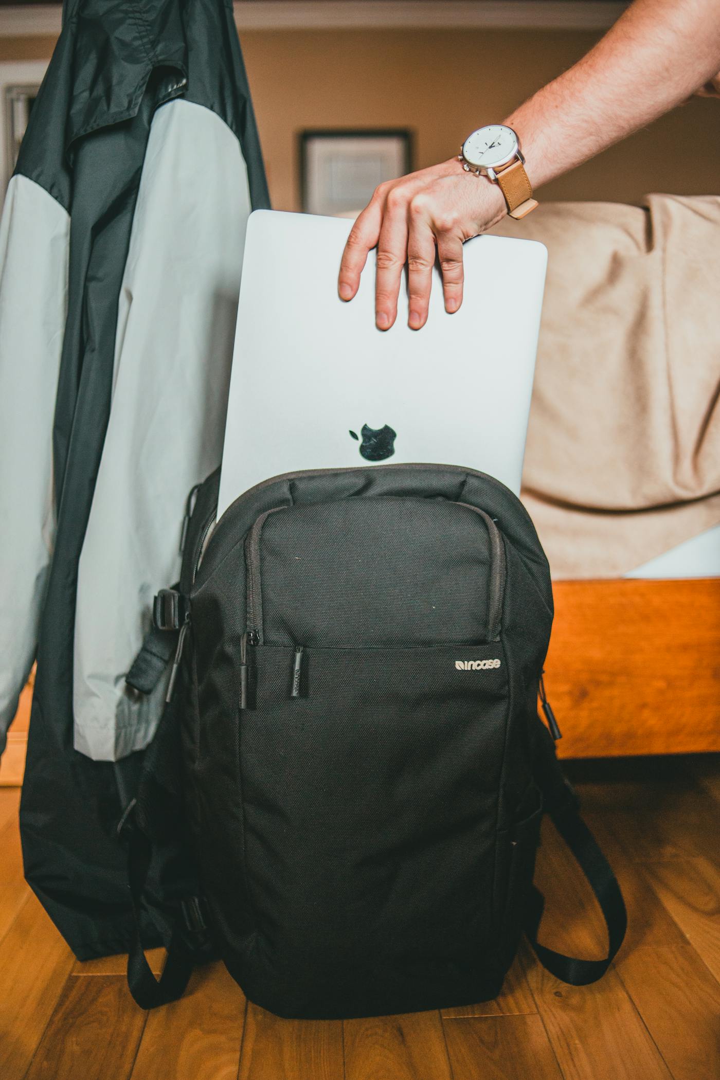 Mano che ripone un laptop nello zaino pronto per il viaggio