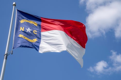 North Carolina Flag on a Pole Under Blue Sky