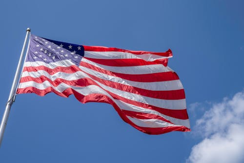 Photo of Cloudy Skies over American Flag · Free Stock Photo